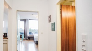 A hotel corridor with wooden flooring, a bed, a radiator, and a view of the outdoors. - Fernblick by Interhome (Winterberg)