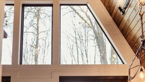 A room with large windows, a dining area, and a view of trees. - HOT TUB and gorgeous lake views-The Lily Pad A Frame-minutes from Dells (Wisconsin Dells)
