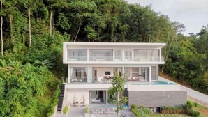 A modern two-story house with a swimming pool, surrounded by lush greenery. - Yamu Hills Panoramic Ocean View 6 Bed Luxury Vila (Pa Klok)