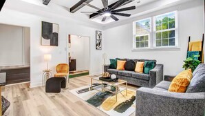 A modern living room with a grey sofa, a coffee table, and a ceiling fan. - Entire home, in Goldsboro North Carolina (Goldsboro)