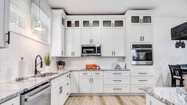 A modern kitchen with white cabinetry, a built-in microwave, and an oven. - Entire home, in Goldsboro North Carolina (Goldsboro)