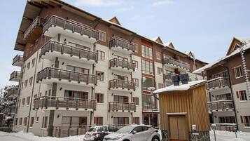 Een hotel met meerdere verdiepingen, balkons, een skilift en een overdekt gebied.