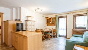 Un espai habitable compacte amb zona de cuina, menjador i sofà.