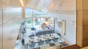 A modern dining area with a long table set for a meal, surrounded by chairs. - Jessamy - Wimborne, Dorset (Wimborne)