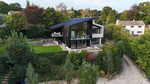 A modern two-story house with a flat roof, large glass windows, and a well-maintained garden. - Jessamy - Wimborne, Dorset (Wimborne)