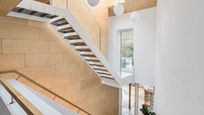 A modern interior with a wooden staircase, a glass door leading outside, and a view of the outdoors. - Jessamy - Wimborne, Dorset (Wimborne)