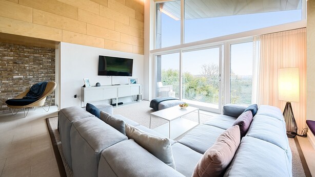 A modern living room with a large sofa, a coffee table, and a TV mounted on the wall. - Jessamy - Wimborne, Dorset (Wimborne)