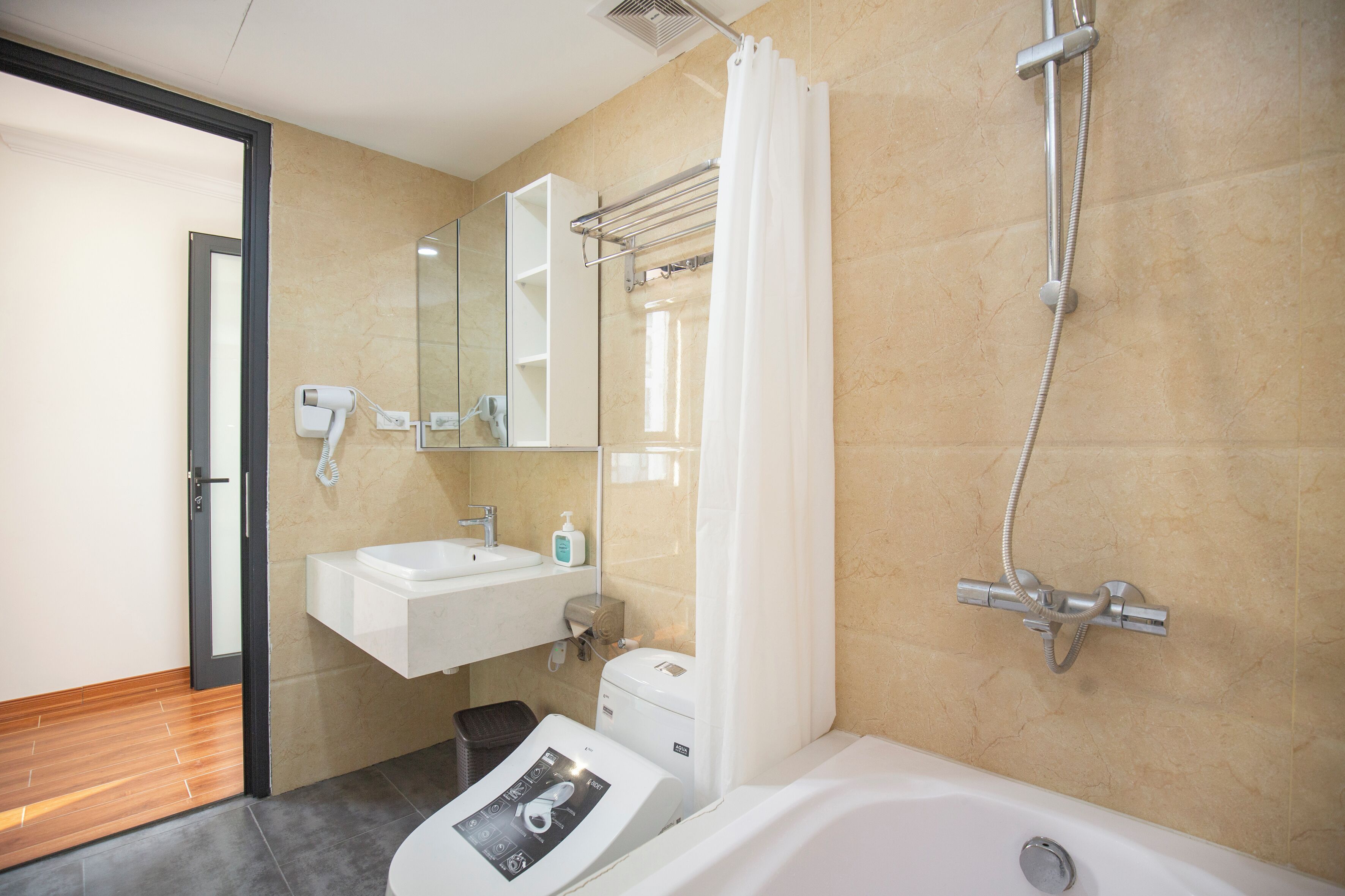 A modern bathroom with a bathtub, a shower, a sink, and a toilet.