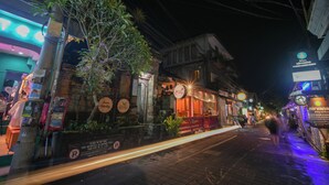 A nighttime street scene with a restaurant named "Bambu" and a neon sign in the background. - Shana Homestay by EPS (Ubud)