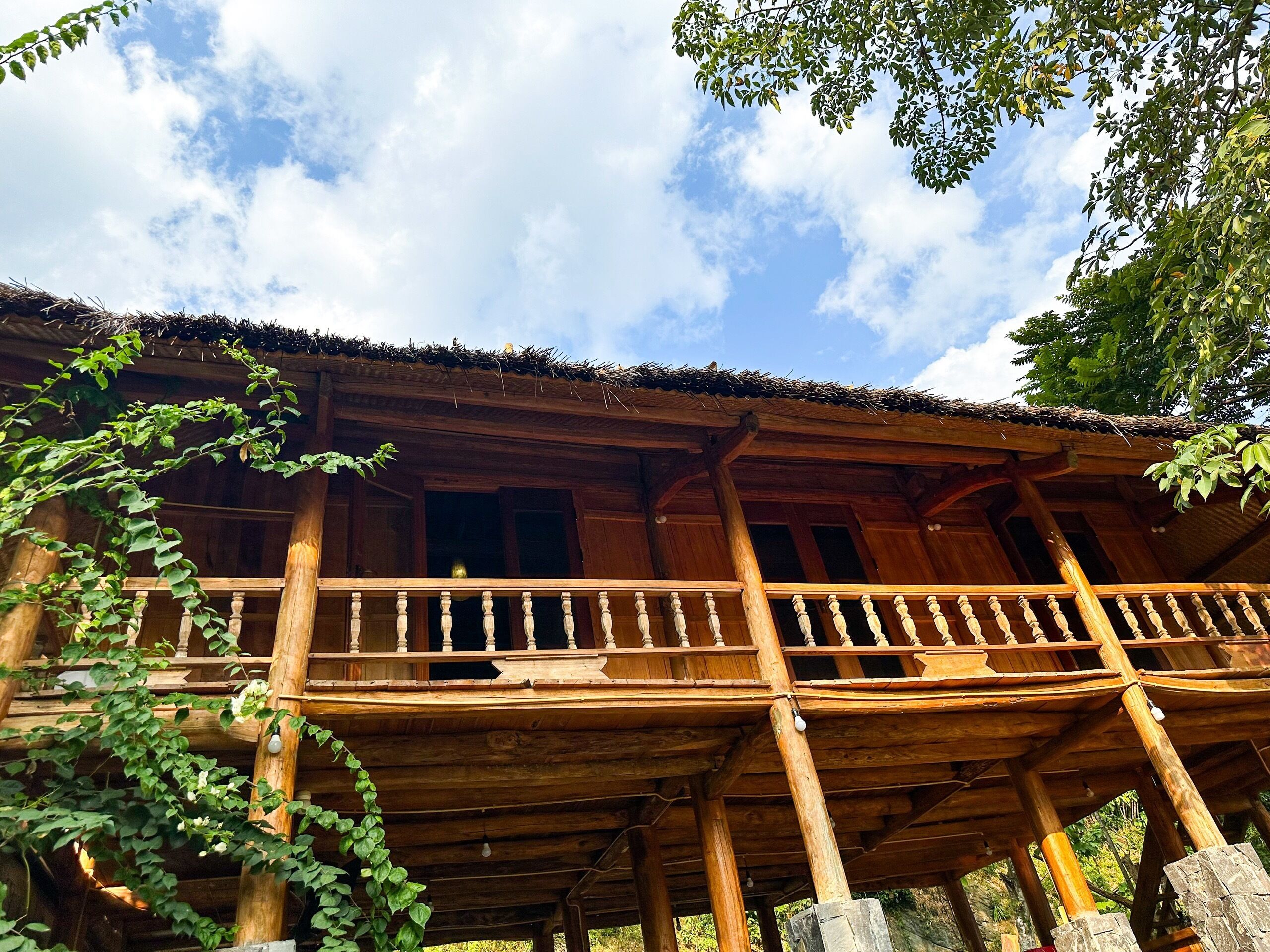 Un bâtiment en bois doté d’un balcon et d’un toit de chaume.