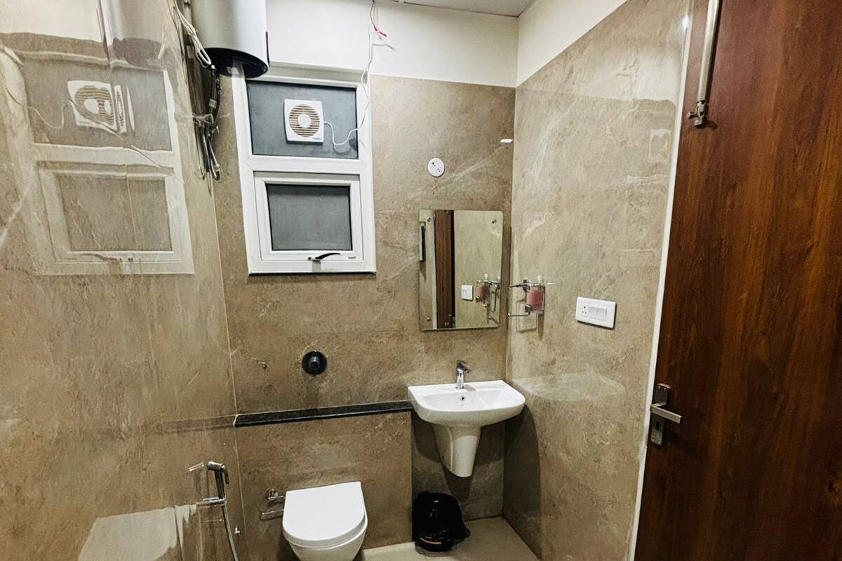 A bathroom with a toilet, sink, and shower.