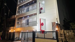 A multi-story building with balconies, air conditioning units, and a gated entrance. - Nirvana inn (Prayagraj)