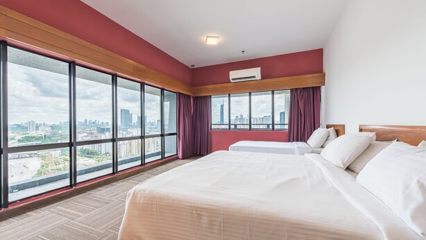 Een hotelkamer met een groot bed, een raam met uitzicht op de stad en een airconditioning.
