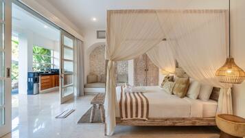 A spacious bedroom with a large bed, a canopy, and a view of the outdoor area.