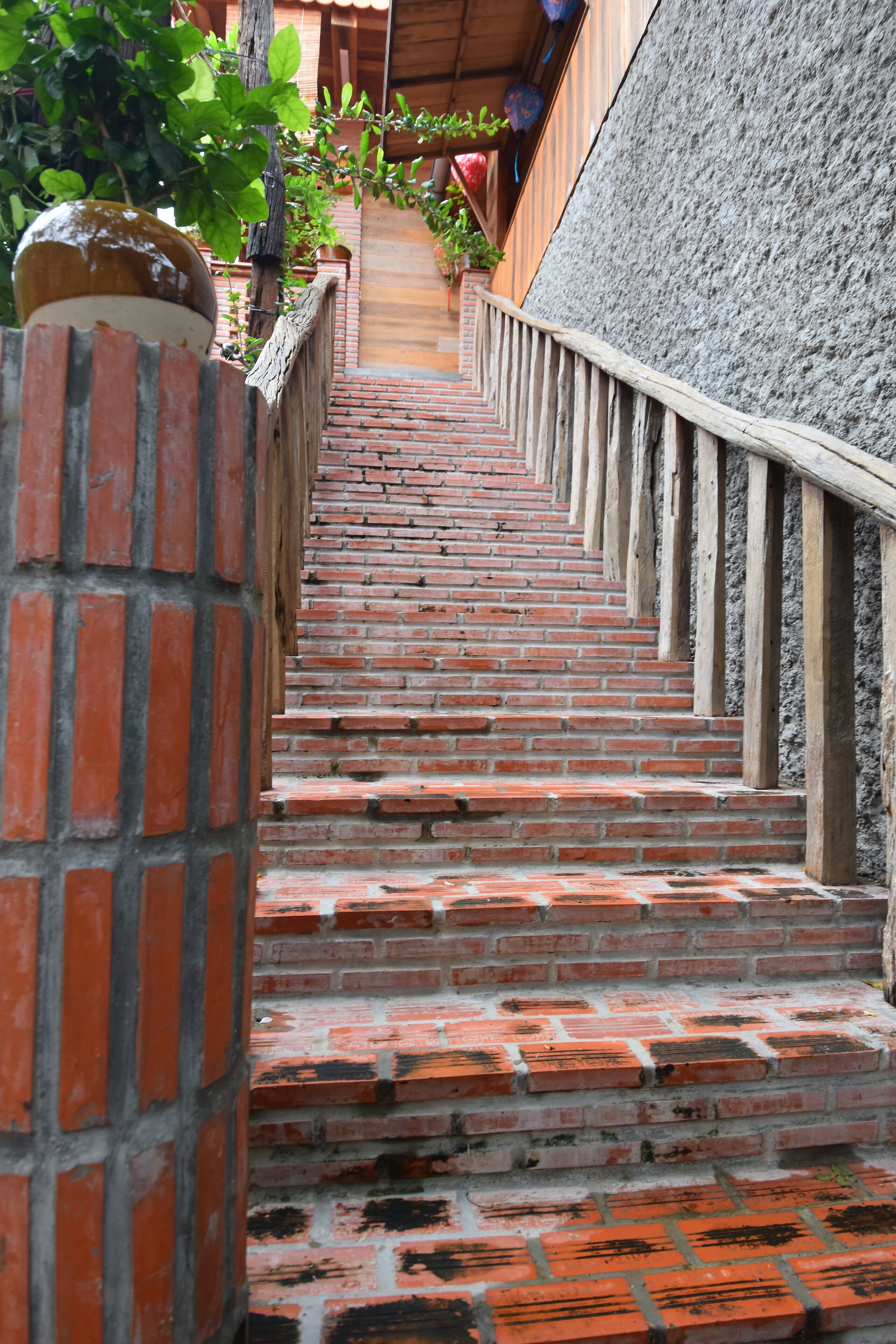 Una escalera de ladrillo con barandilla de madera que sube.