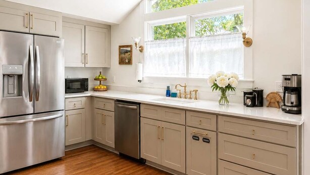 A modern kitchen with a stainless steel refrigerator, a dishwasher, and a coffee maker.