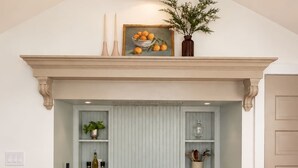 A kitchen with a stove, oven, and a decorative mantelpiece above.