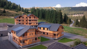 A modern wooden building with multiple balconies, surrounded by a mountainous landscape and a clear sky. - mit 2 Schlafzimmern & Sauna by Interhome (Niederwölz)