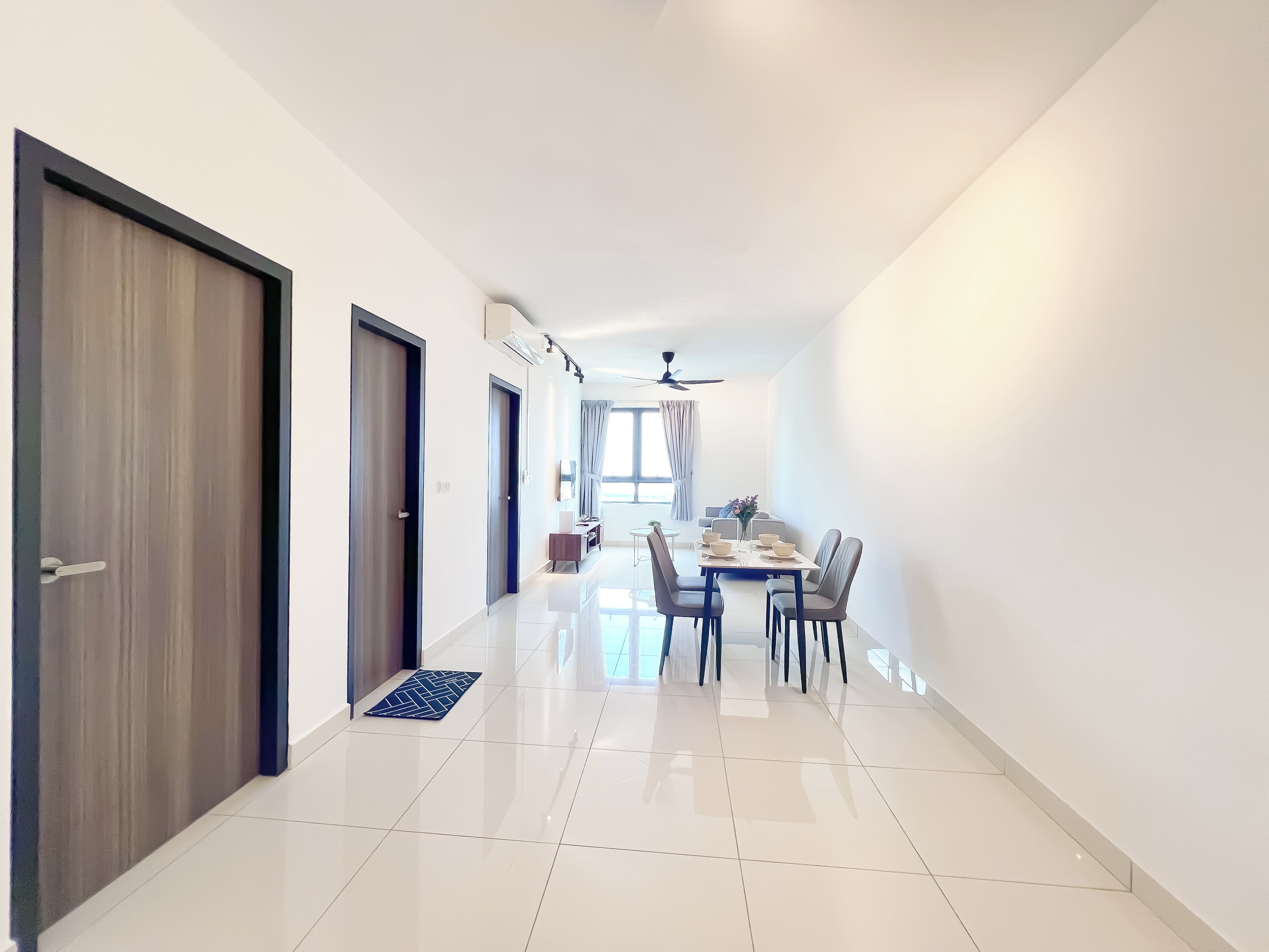 A modern hotel corridor with a dining area featuring a table and chairs, a ceiling fan, and a view of the outdoors.