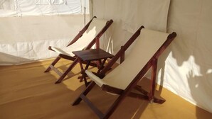 Una habitación con sillas de madera y una cortina blanca.