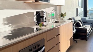 A modern kitchen with a built-in oven, microwave, and coffee machine.
