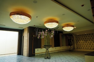 Um quarto espaçoso com uma grande janela, um candelabro e uma mesa decorada com flores.