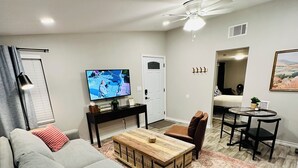 A living room with a grey sofa, a wooden coffee table, a TV, and a ceiling fan. - Chic 1-bedroom apartment in  Springtown, TX with AC, WiFi (Springtown)