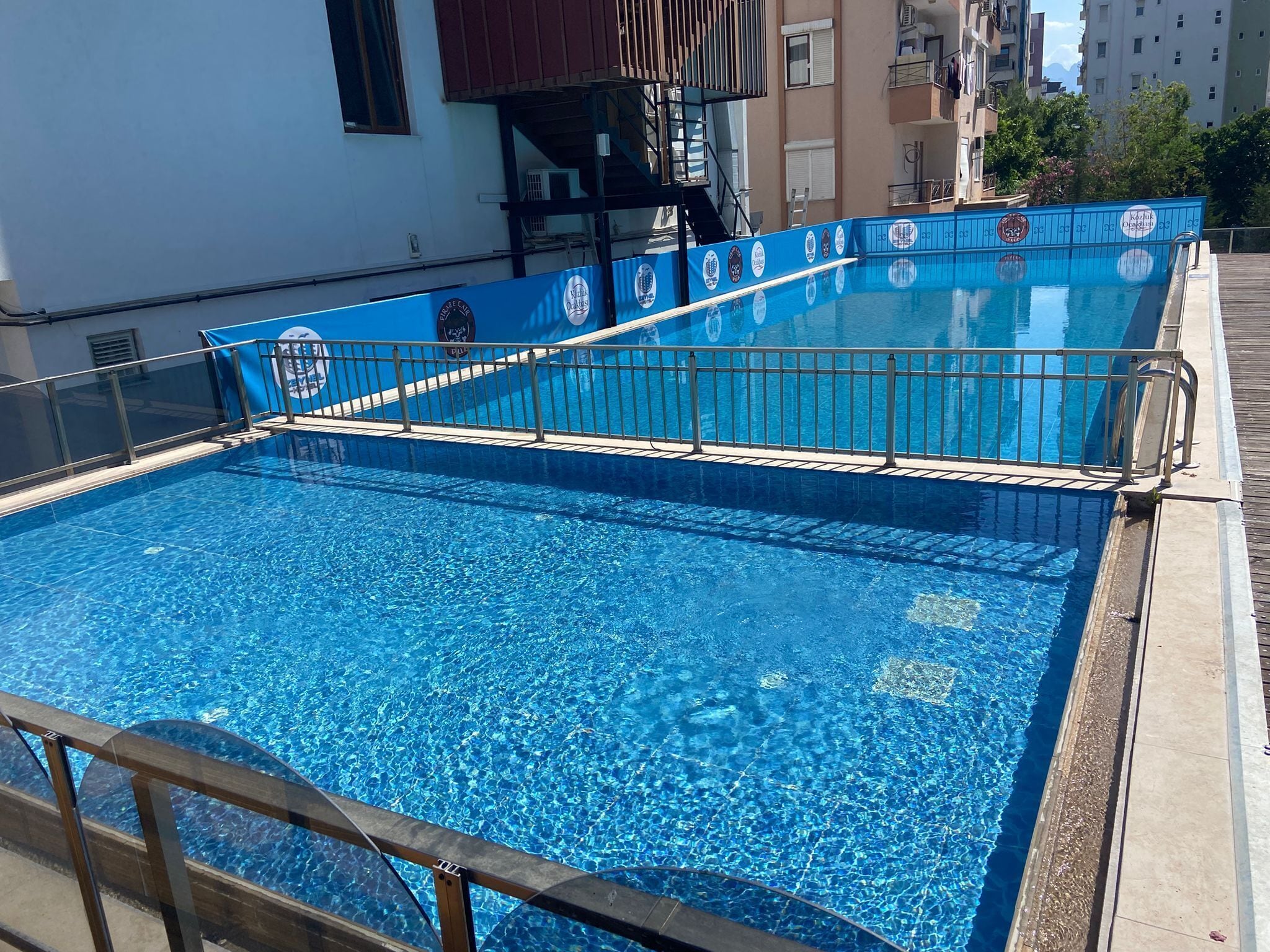 Una piscina al aire libre de temporada, sombrillas