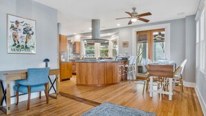 Une cuisine moderne dotée d’un îlot central, de meubles en bois et d’un ventilateur de plafond.