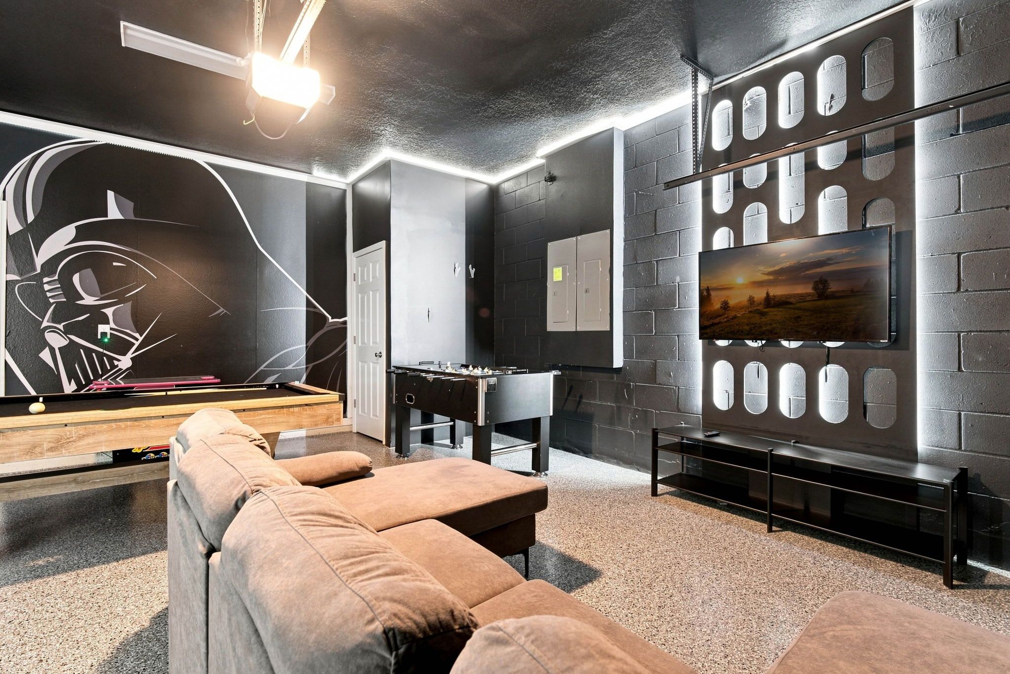 A modern lounge area with a pool table, comfortable seating, and a mounted TV.