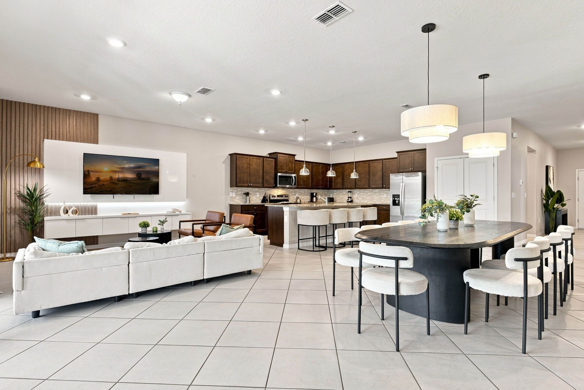 A modern kitchen with a central island, built-in appliances, and pendant lighting.