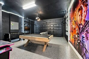Une pièce équipée d’une table de billard, d’un baby-foot et d’un mur décoré sur le thème de Star Wars.