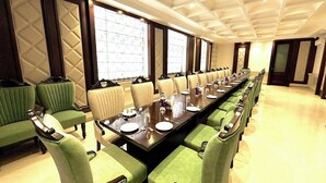 A conference room with a long table, green upholstered chairs, and a patterned ceiling. - HOTEL SUKH FARM (Sangrur)