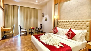 A hotel room with a large bed, a desk, and a chair. - HOTEL SUKH FARM (Sangrur)