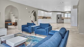 A modern living room with blue sofas, a white coffee table, and a patterned rug. - Grand Casa • 8bdr • Strip Views• 21 Beds • Free Spa Heat • Basketball • Events (Las Vegas)