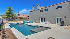 A swimming pool with a stone facade house, outdoor seating, and a clear blue sky. - Grand Casa • 8bdr • Strip Views• 21 Beds • Free Spa Heat • Basketball • Events (Las Vegas)