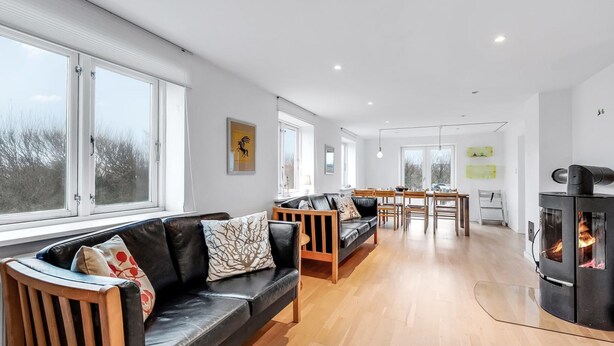 A modern living room with a fireplace, wooden furniture, and large windows. - "Laurentia" - 200m from the sea by Interhome (Harboøre)