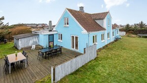 A light blue house with a wooden deck, a small shed, and a grassy yard. - "Laurentia" - 200m from the sea by Interhome (Harboøre)