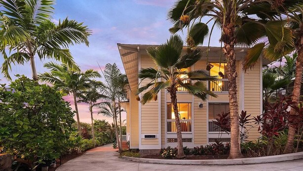 A modern two-story building with a curved driveway, surrounded by tropical vegetation. - Kona Polynesian King - Tropical Island Soul (Kailua-Kona)