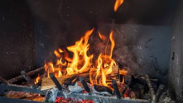A fireplace with burning logs and flames.