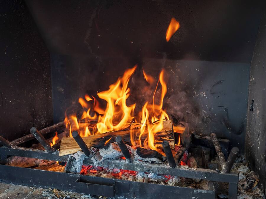 A fireplace with burning logs and flames.