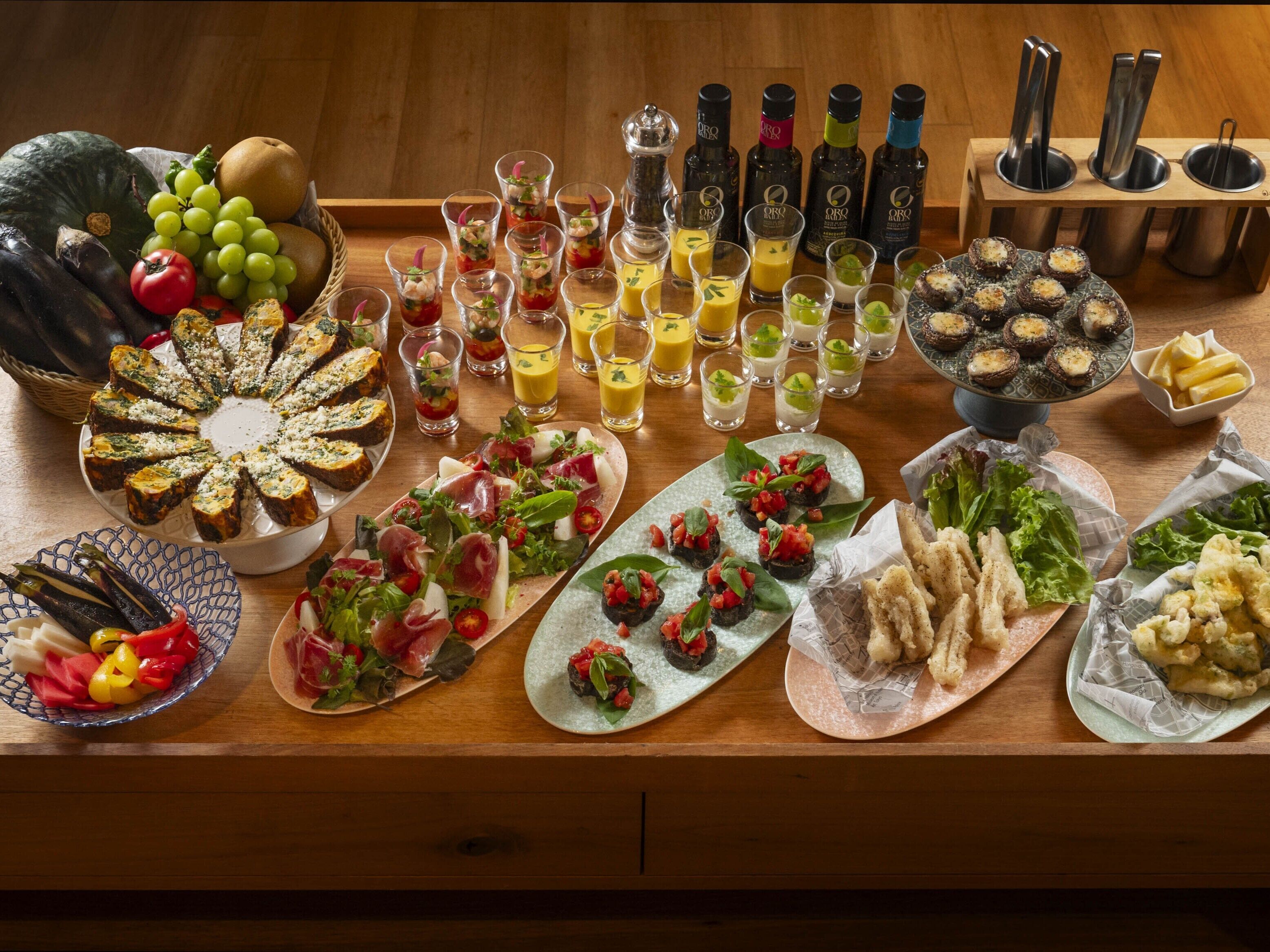 A variety of appetizers and drinks on a wooden table.