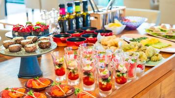 A buffet table with various food items and drinks.