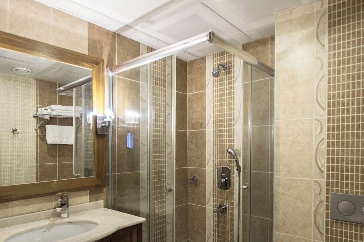 Un baño moderno con ducha acristalada, lavabo e inodoro.