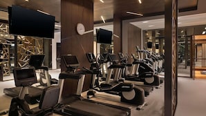 A gym with treadmills, stationary bikes, and ellipticals, with a clock on the wall and a TV screen. - Sofitel Riyadh Hotel & Convention Centre (Riyadh)