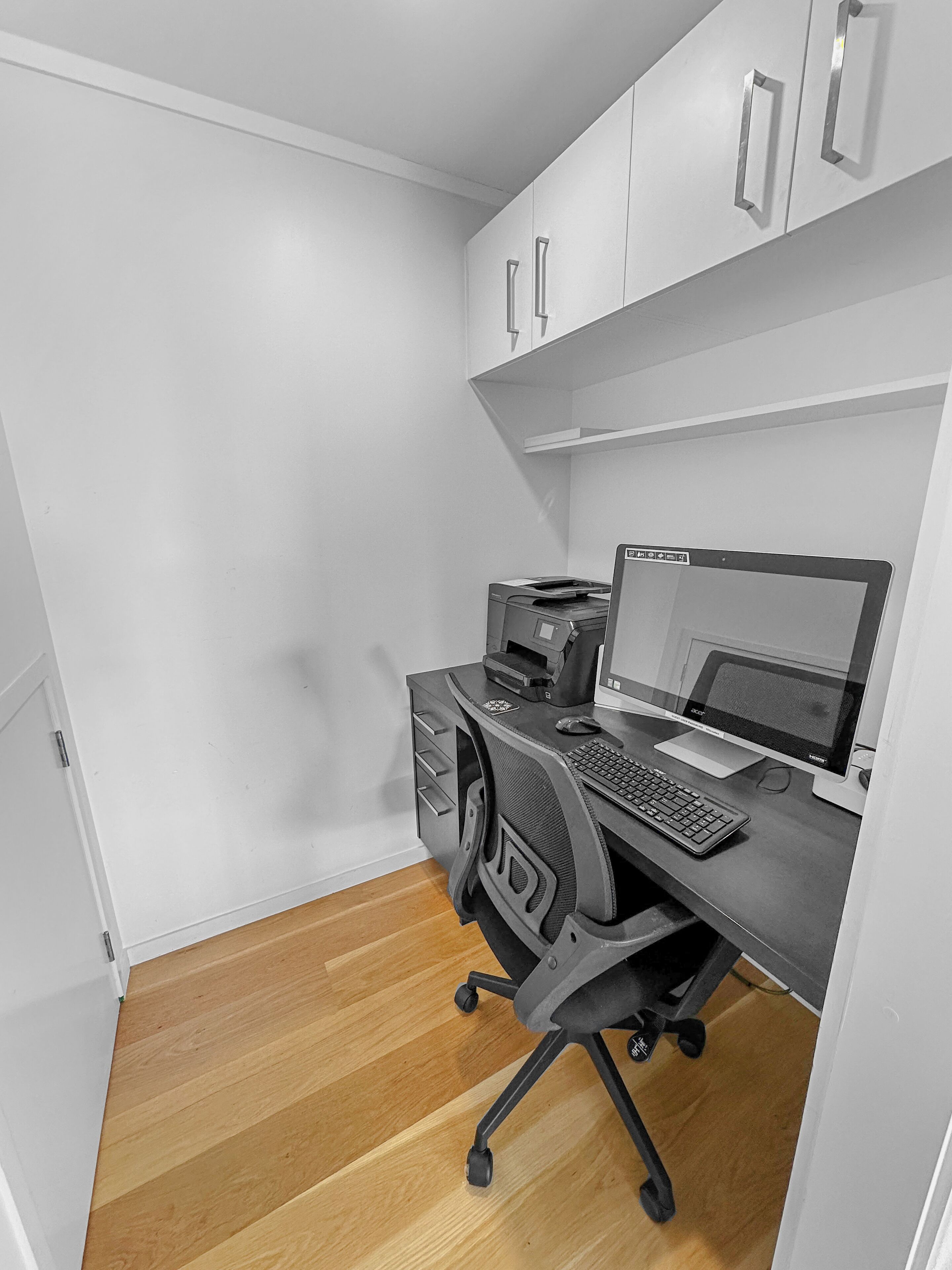 A compact office space with a desk, computer, and printer.