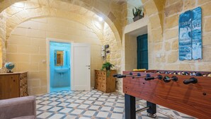 A room with a foosball table, a wooden cabinet, a globe, and a blue door. - Ellie Boo - Farmhouse w/ Pool, Hot Tub, Games Room (Xewkija)