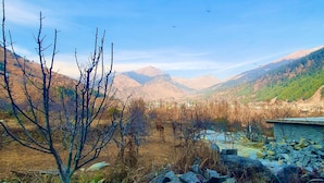 A mountainous landscape with a clear sky, rocky terrain, and sparse vegetation. - Ekaant Stays - Manali (Manali)