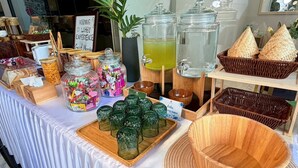 A table with jars of snacks, a water dispenser, and woven baskets.