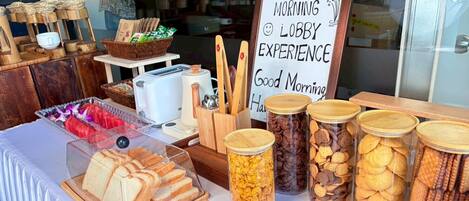 Una mesa de desayuno con pan, galletas y un cartel que dice 'MORNING LOBBY EXPERIENCE'.